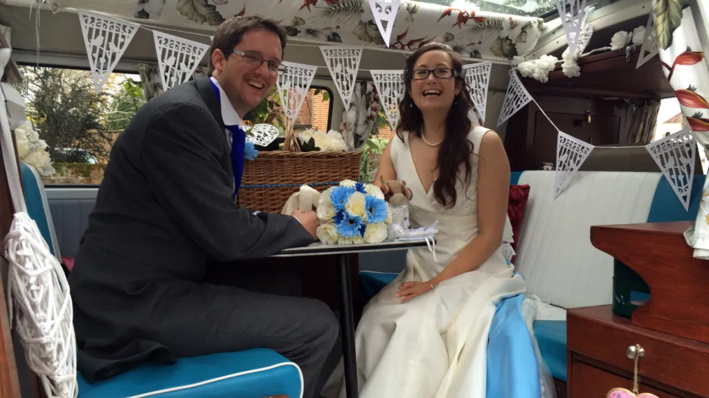 Bride and Groom seating inside a classic VW Campervan