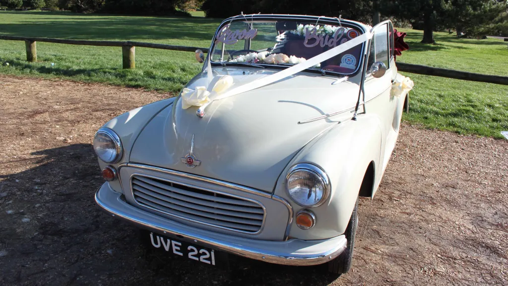 Front view of classic Morris Minor Convertible dressed with traditional "V-shape" white ribbons and bows