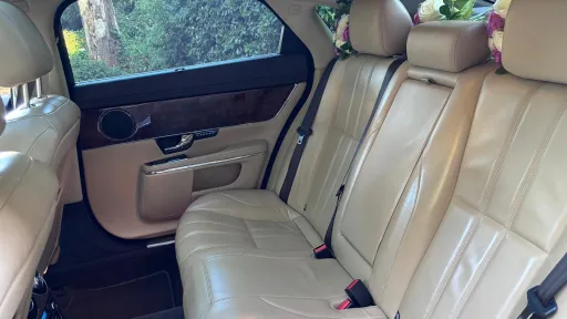 White Jaguar XJ LWB rear cream leather interior with wooden features on top of the door cards