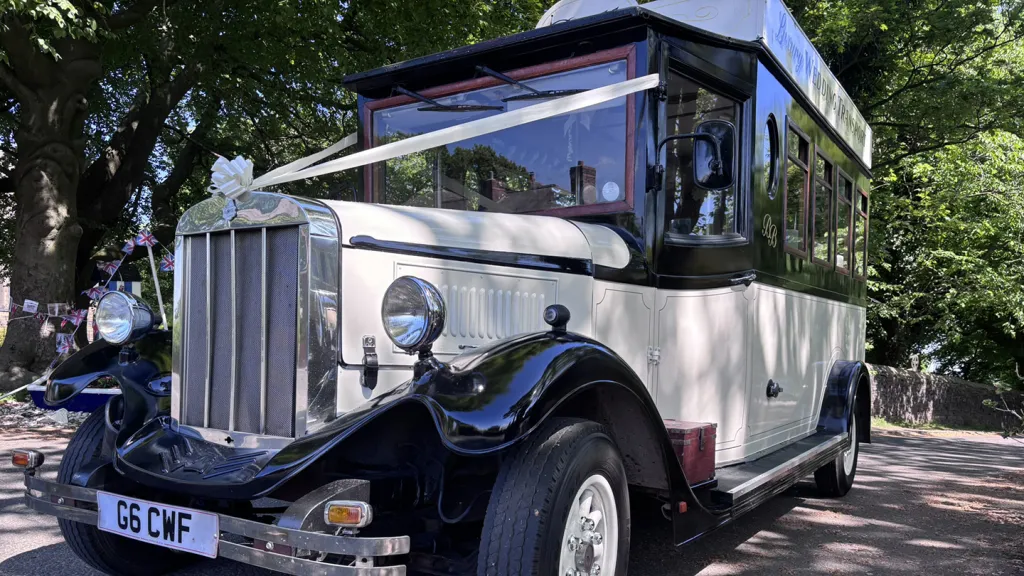 Close up view of front grill of Ivory Asquith Bus wqith black wheel arches