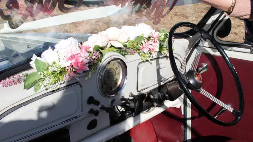 Classic Morris Minor Convertible fron dashboard decorated with with and pink flowers on dashboard
