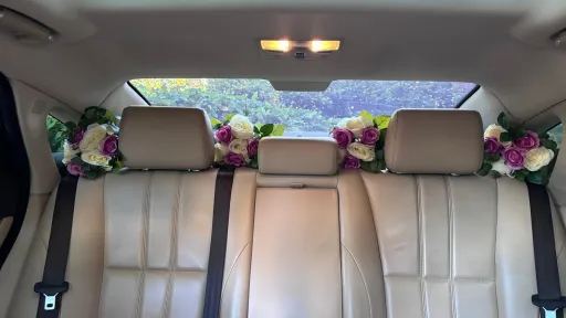 rear cream leather interior seat in Jaguar XJ with floral decoration on rear parcel shelf.