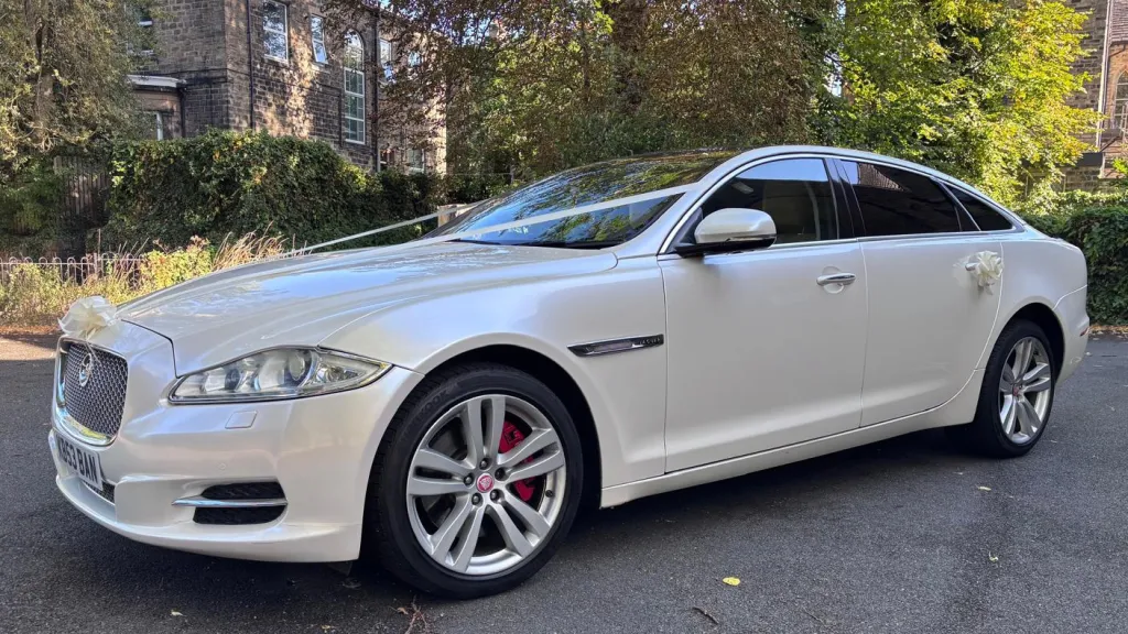 White Jaguar XJ LWB with privacy tinted windows and chrome alloy wheels