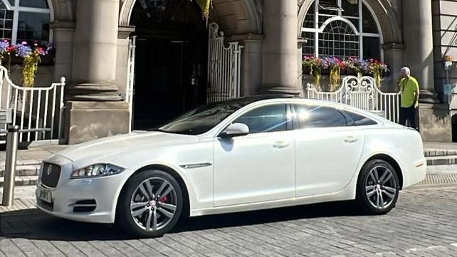 White Jaguar XJ parked in front of registrar office in Leeds
