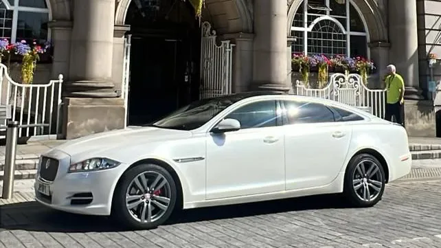White Jaguar XJ parked in front of registrar office in Leeds