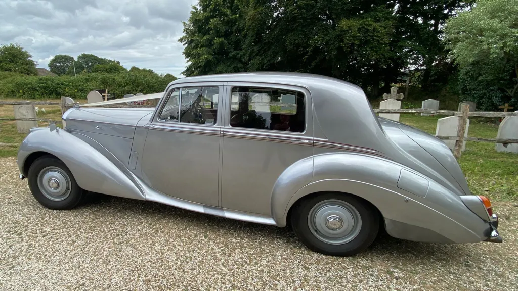 Side view of a silver Bentley R-Type showing its sweeping curved wings