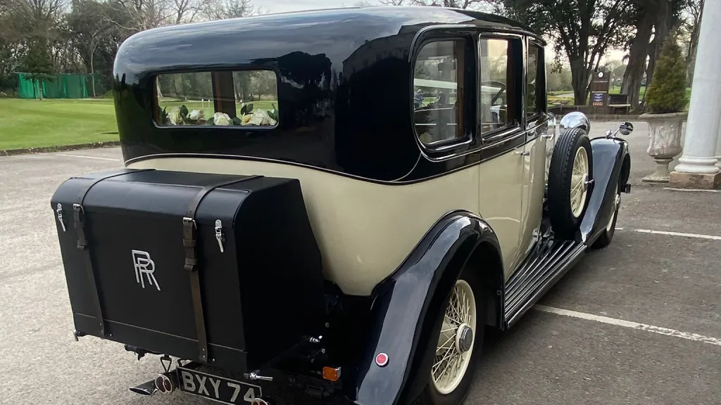 Rear view of a black and ivory vintage Rolls-Royce 20/25 limousine