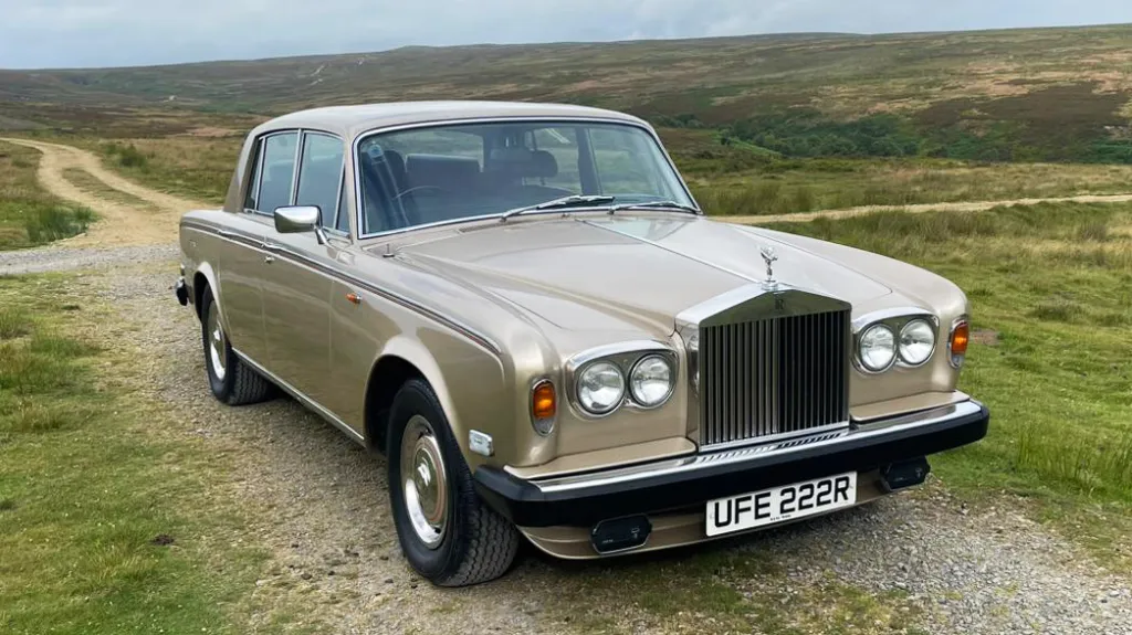 Front angle view of a gold Rolls-Royce Silver Shadow on a country lane, available for weddings in Yorkshire.