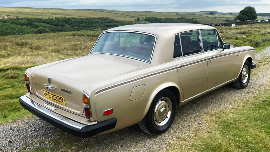 Rear view of a gold Rolls-Royce Silver Shadow showing its classic tail lights and chrome bumper, available for wedding hire in Yorkshire.