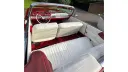 Interior of a classic red Dodge convertible showing white leather seats with red trim and a red dashboard.