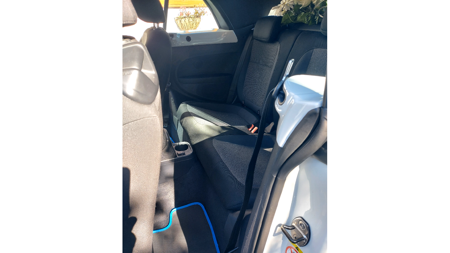 Rear interior seating of a modern Volkswagen Beetle convertible with black leather upholstery and compact cabin layout.