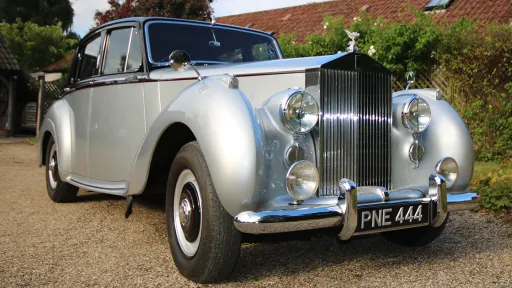 Front view of a 1954 Rolls-Royce Silver Dawn showing its chrome grille, large headlights and registration plate PNE 444.