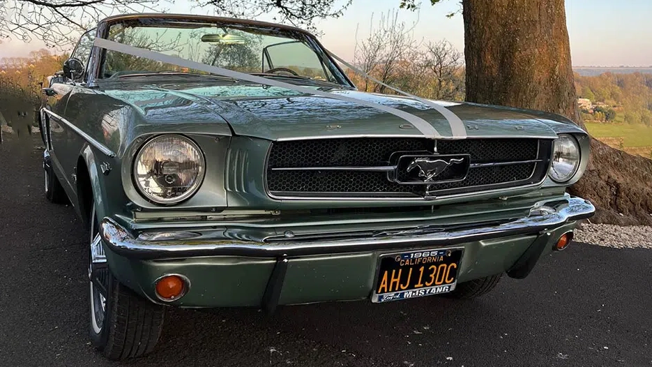 Front view of a vintage Ford Mustang convertible showing its iconic pony grille badge, chrome bumper and round headlights.
