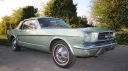 Right side angled view of a vintage Ford Mustang convertible with chrome wheels, parked under trees in Dorset.