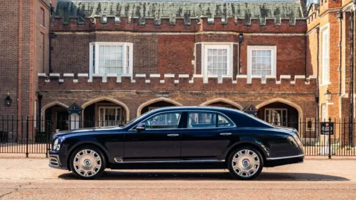 Left sode view Blue Bentley Mulsanne parked in front of a red brick wedding venue