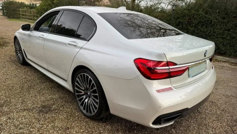 Rear left side view of white modern BMW 7 series