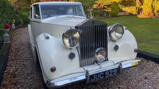 Front view of a white 1948 Rolls-Royce Silver Wraith showing its polished chrome grille, twin headlamps, and Spirit of Ecstasy bonnet mascot.