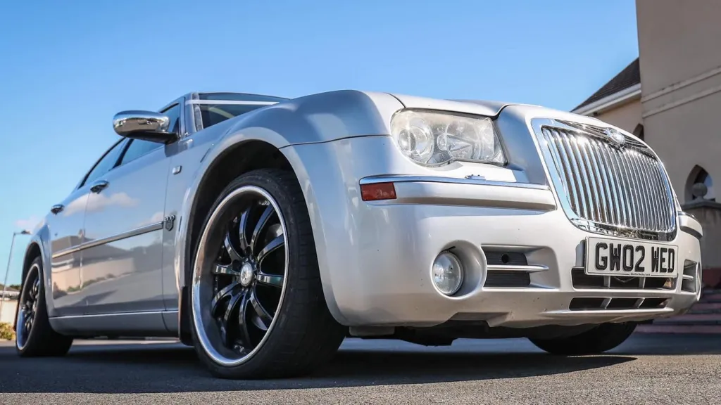 Silver Chrysler 300C parked on a sunny day in Belfast, Northern Ireland, with black alloy wheels and polished chrome details.