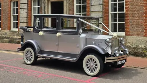 Right side view of a silver Imperial vintage wedding car with elegant chrome detailing parked on a Sussex driveway.