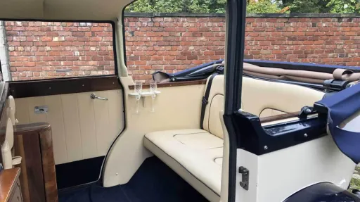 Convertible rear interior of a cream and navy blue Regent wedding car showing spacious seating and polished wood detailing.