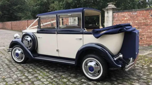 Cream and navy blue Regent convertible wedding car parked on cobblestone in Liverpool, with the roof folded down and chrome details shining.
