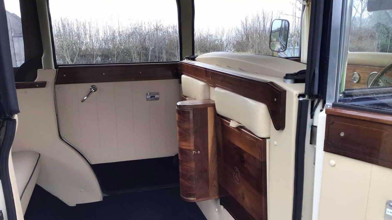 Interior view of the Regent wedding car showing cream leather seats, wooden door trim, and elegant vintage styling.