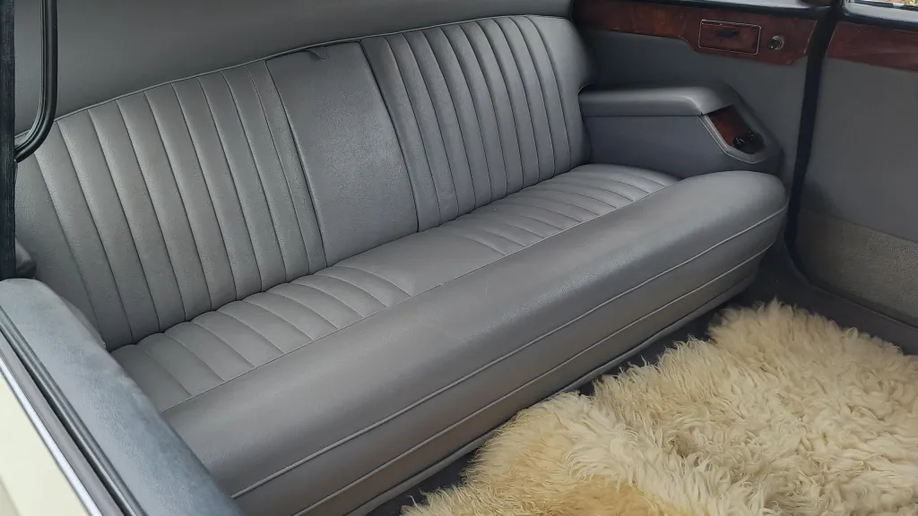 Silver-grey leather interior of a Daimler DS420 limousine with a long rear bench seat and spacious cabin.