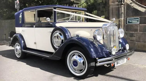 Classic Regent wedding car in two-tone cream and navy blue, photographed in Liverpool with wedding ribbons attached to the bonnet.