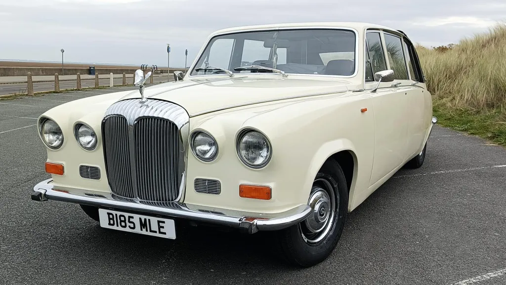 Ivory Daimler DS420 limousine parked outdoors in emplty parking near Preston with grey covered clouds