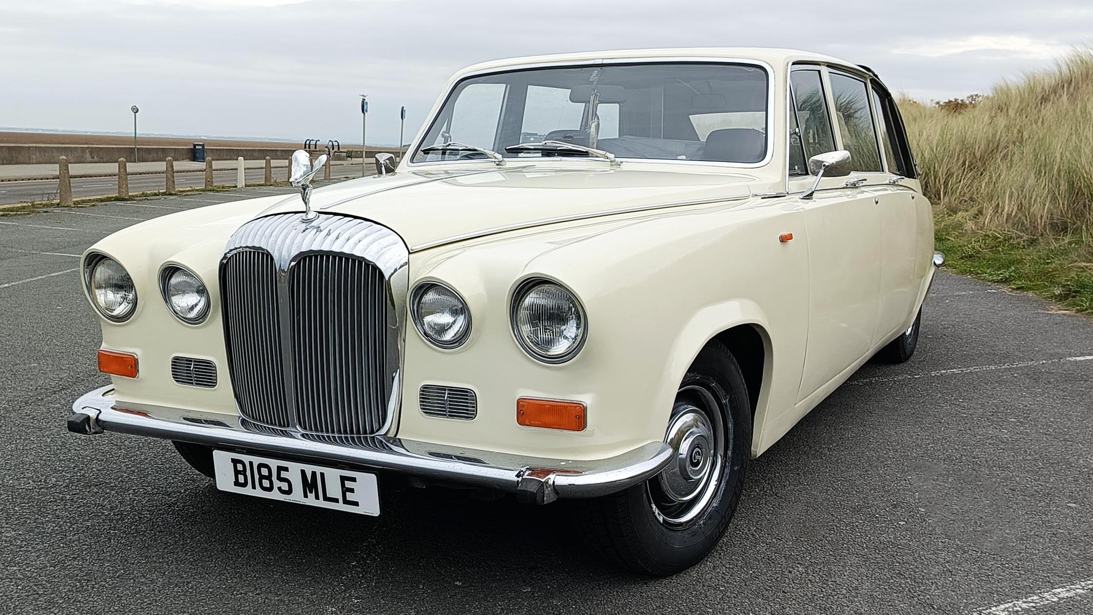 Ivory Daimler DS420 limousine parked outdoors in emplty parking near Preston with grey covered clouds