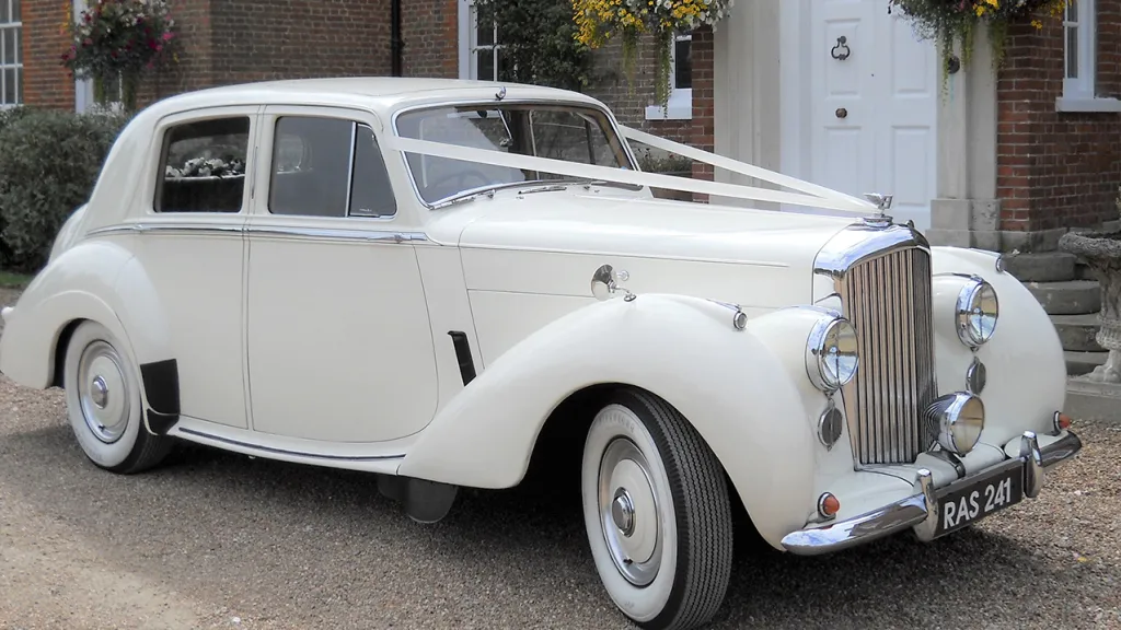 Right side view Bentley R-type with white wedding ribbons and whitewall tires