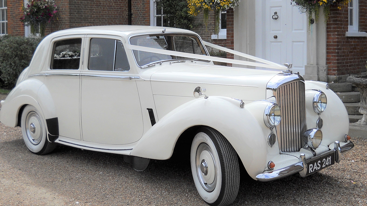 Right side view Bentley R-type with white wedding ribbons and whitewall tires