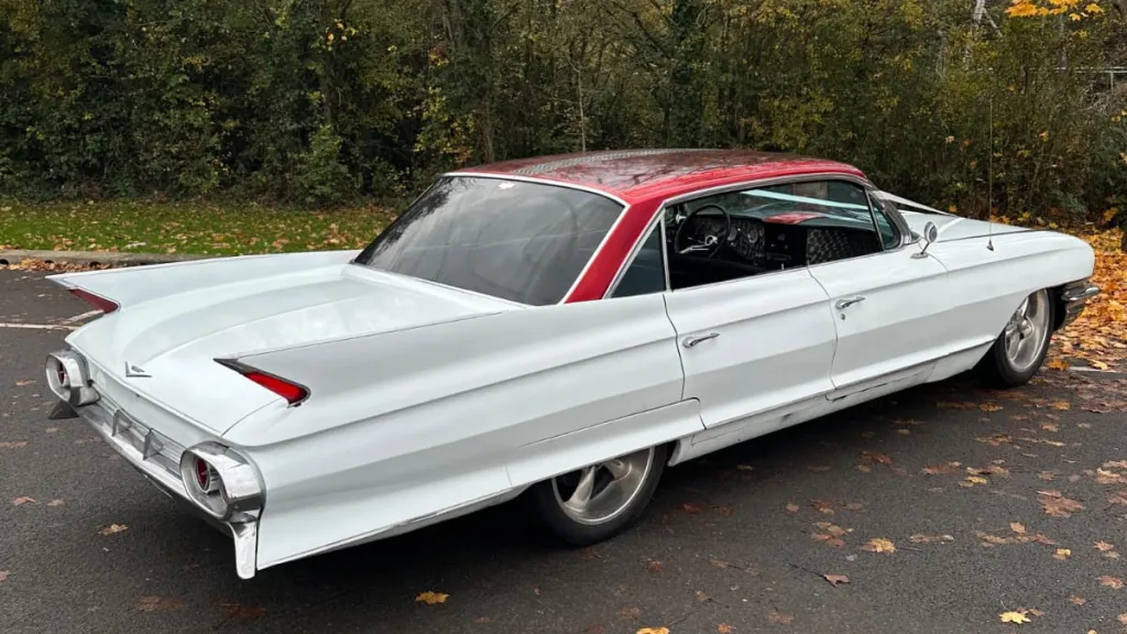 Right side exterior view of a white classic American Cadillac parked on driveway.