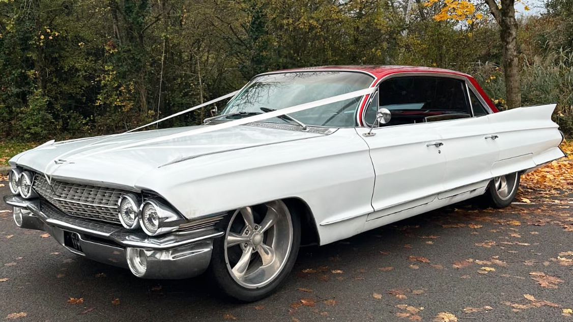 White classic American Cadillac wedding car parked outdoors ready for hire.