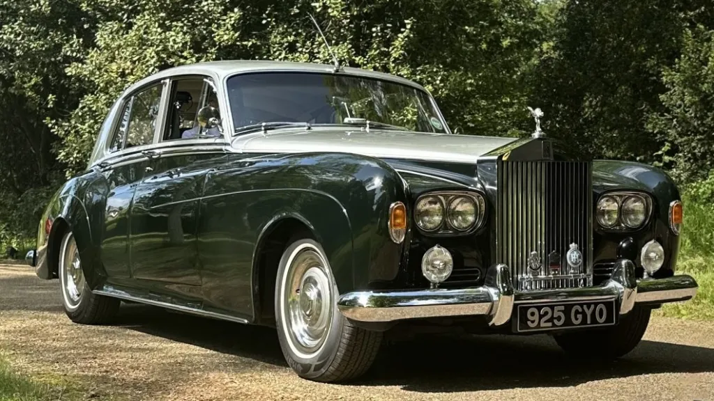 classic green Rolls-Royce Silver Cloud wedding car parked outside venue