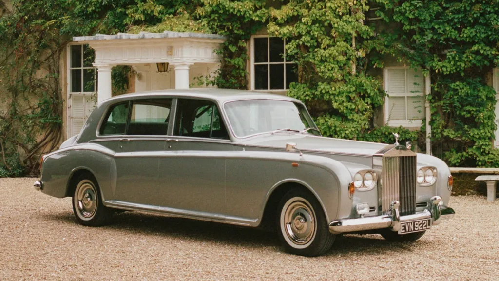 Silver classic Rolls-Royce limousine parked outside a stately home for a wedding.
