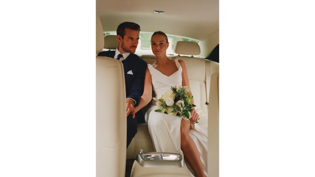 wedding couple seated in the back of Rolls-Royce Ghost with a cream leather interior