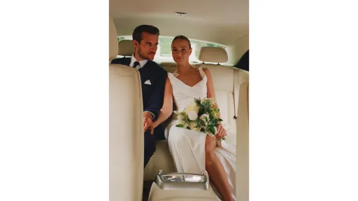 wedding couple seated in the back of Rolls-Royce Ghost with a cream leather interior