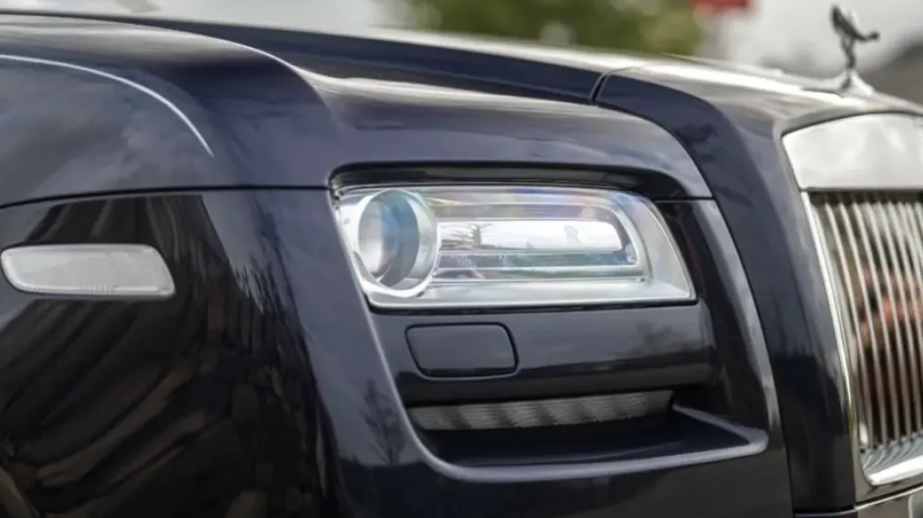close-up of Rolls-Royce Ghost headlight and chrome grille
