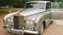 Front view of a silver Rolls-Royce Phantom limousine with chrome grille and Spirit of Ecstasy emblem.