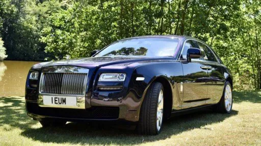 Indigo blue and purple Rolls-Royce Ghost wedding car with trees in background