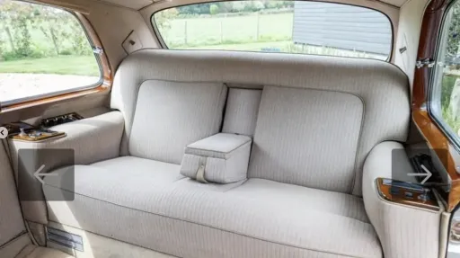 ear interior seats of a classic Rolls-Royce Phantom showing plush upholstery and wood trim.