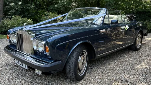 Bl;ue copnvertible classic rolls-royce with lilac ribbons