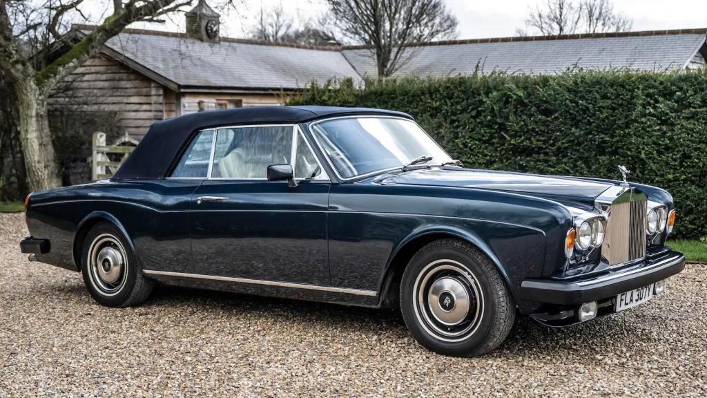Right side view of a blue rolls-Royce Corniche witrh blue soft top roof closed