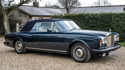 Right side view of a blue rolls-Royce Corniche witrh blue soft top roof closed
