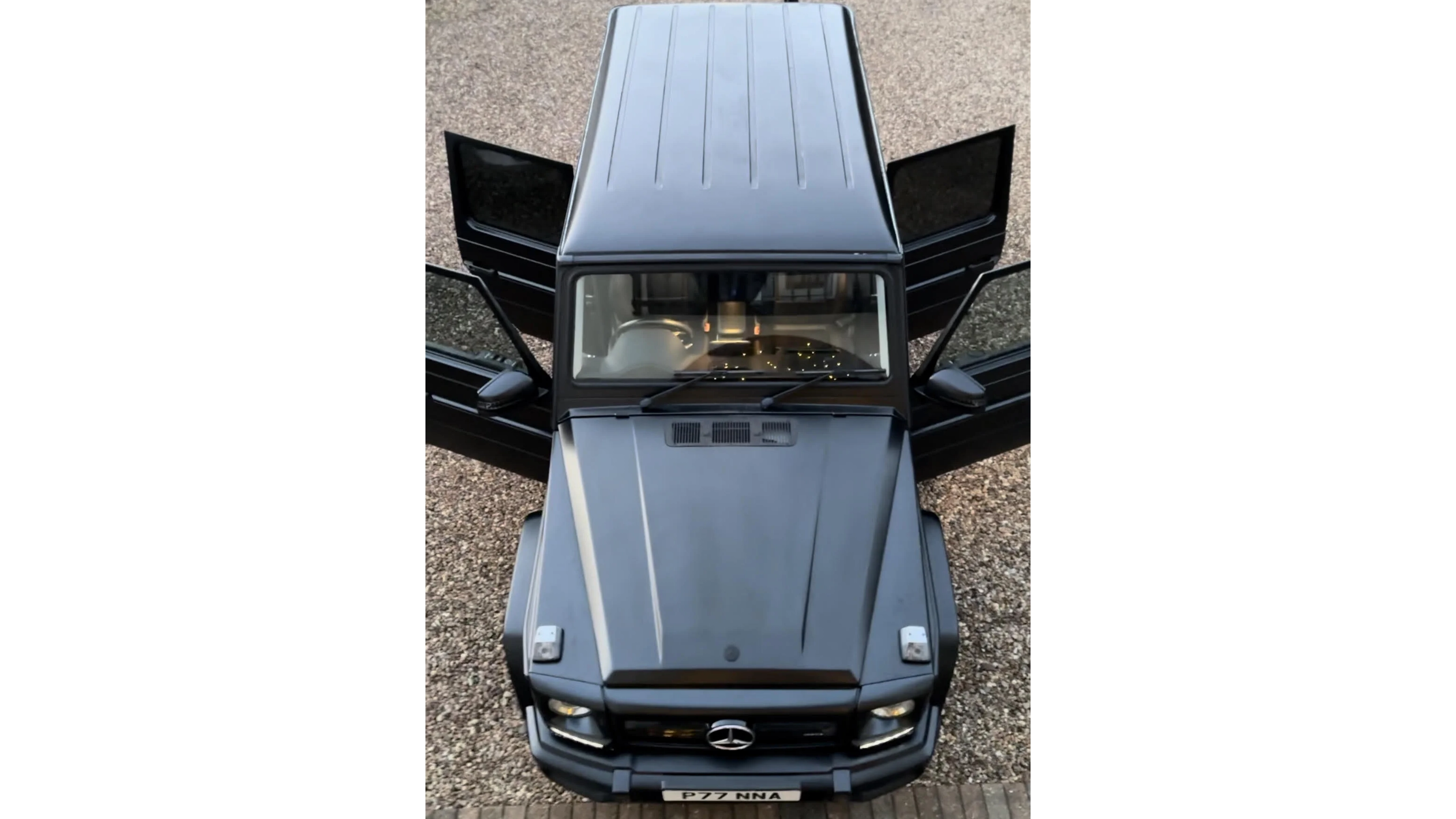 Aerial view of a black Mercedes G-Wagon with all doors open at a wedding venue