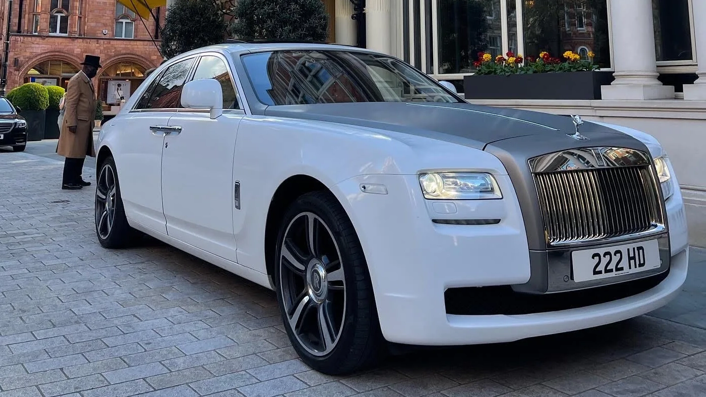 White Rolls-Royce Ghost with a polished silver bonnet parked in front of an elegant building.