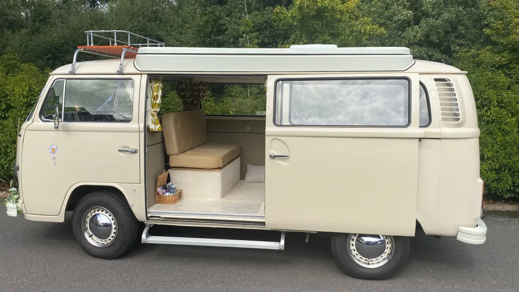 Left side view of a classic VW Campervan with rear passenger sliding door open