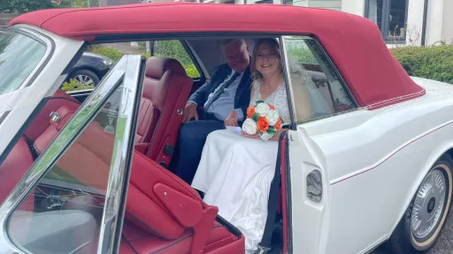 Couple seating inside a white rolls-royce