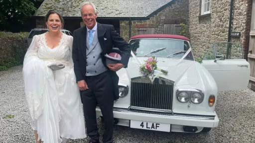Couple standing in front of a classic White rolls-Royce at a Devon venue
